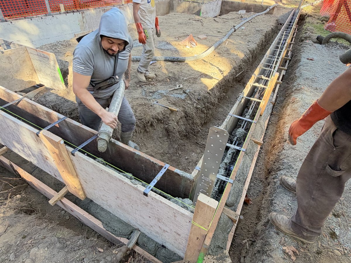 Crew setting stem wall forms with rebar on the footings