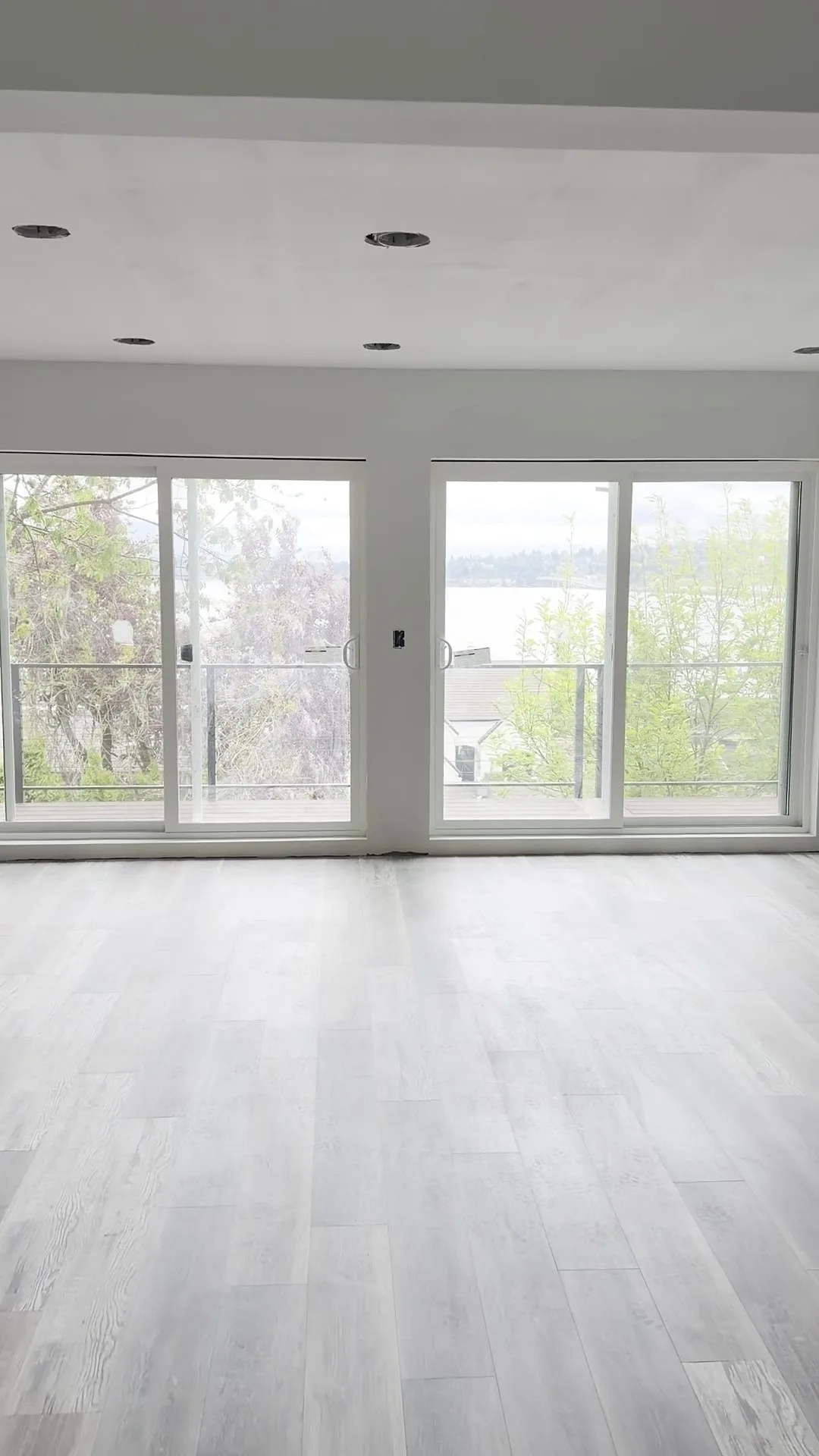 Finished great room with floor-to-ceiling sliders open to the Lake Washington view