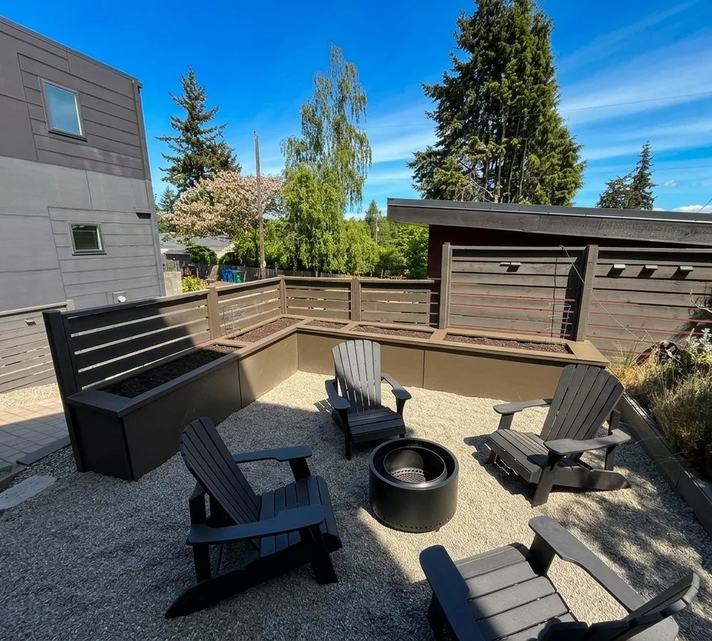 Gravel fire pit lounge with adirondack chairs and planter boxes