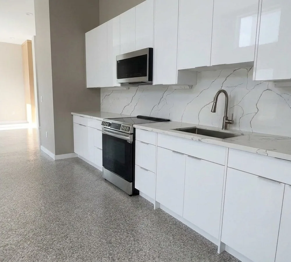 Finished Magnolia DADU kitchen with white gloss cabinets and quartz backsplash