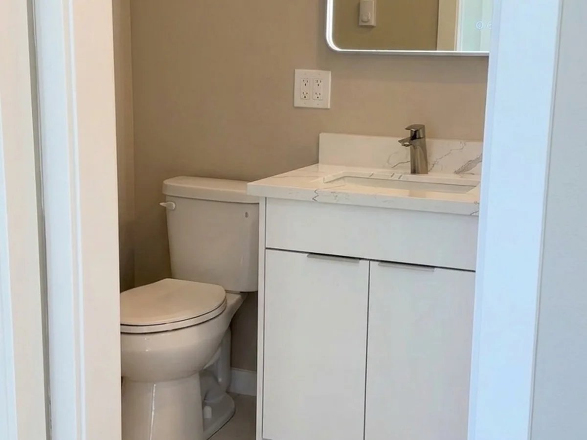 Finished bathroom with marble vanity and LED mirror