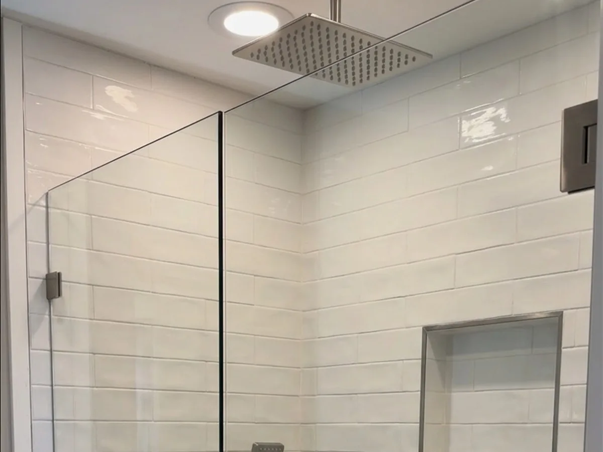 Walk-in shower with square rain head, white subway tile and glass panel