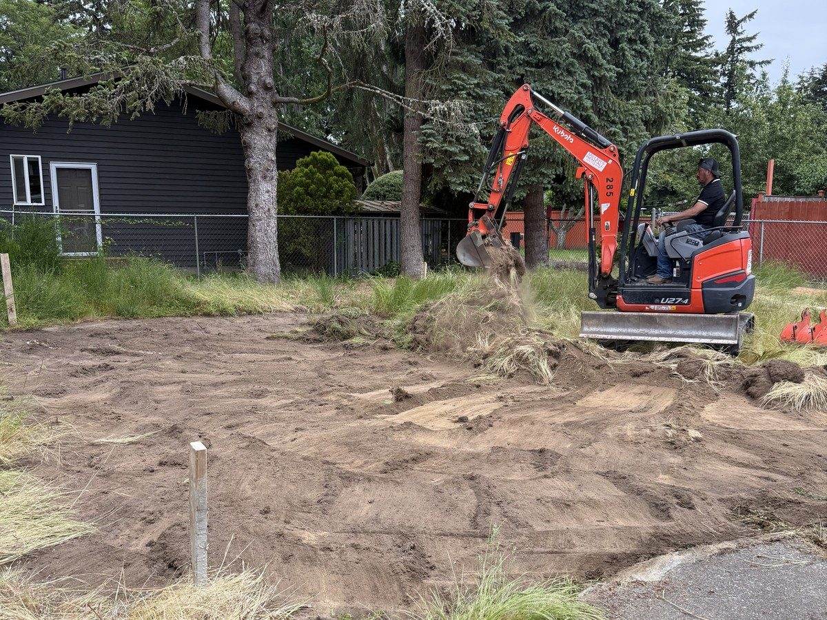 Mini excavator clearing grass from the ADU lot