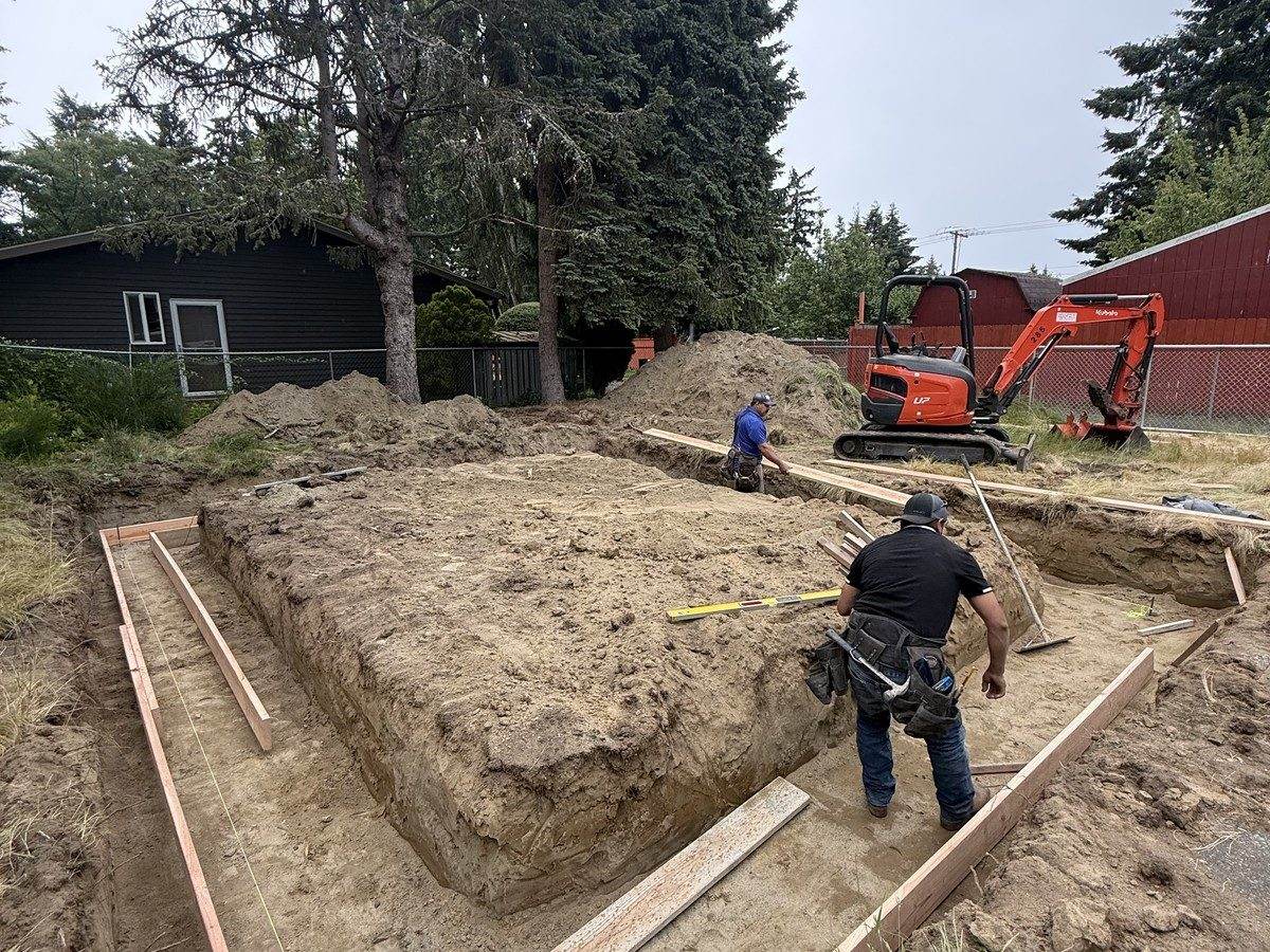 Footing trench cut with form lumber staged