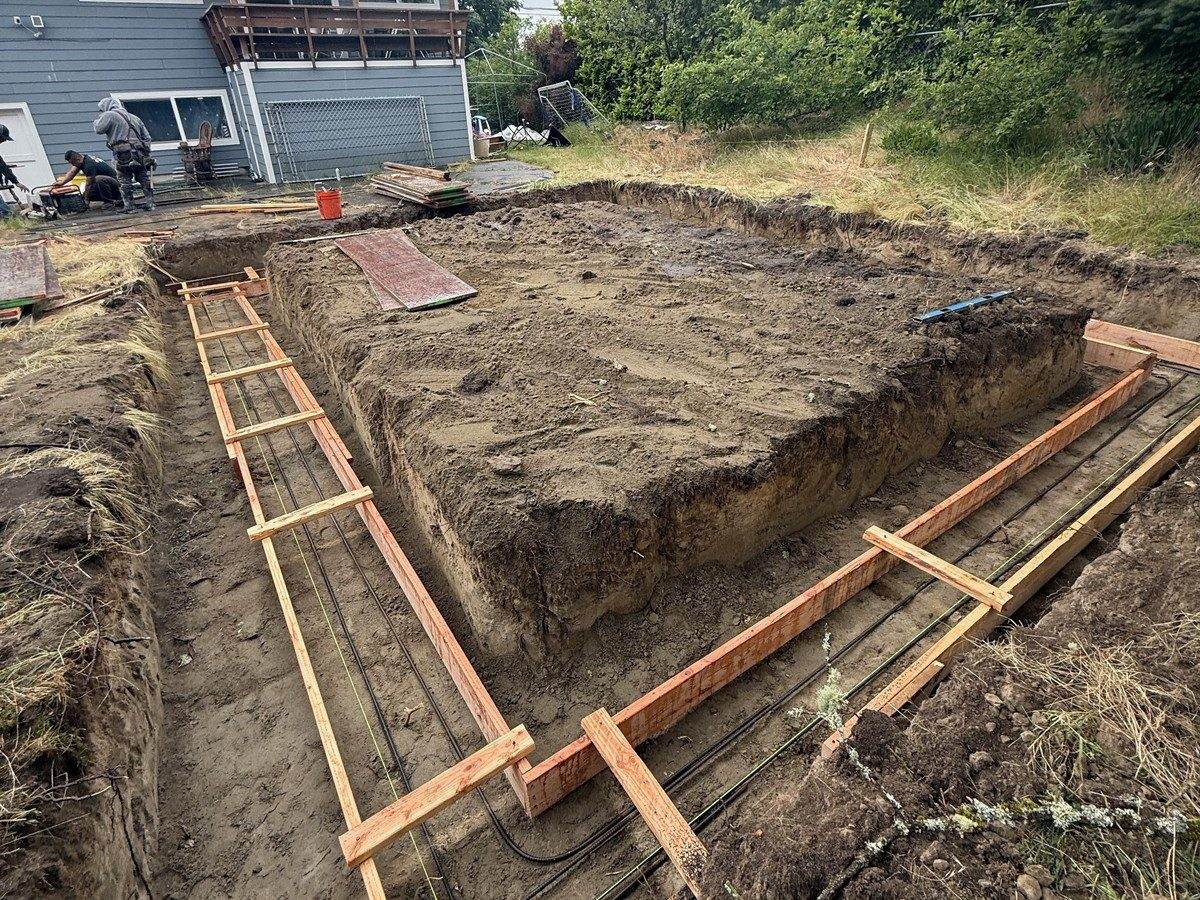 Footing forms and rebar laid out over the trenches