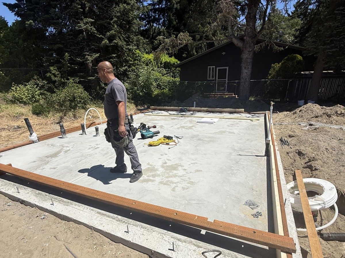 Finished concrete slab with anchor bolts and plumbing stubs