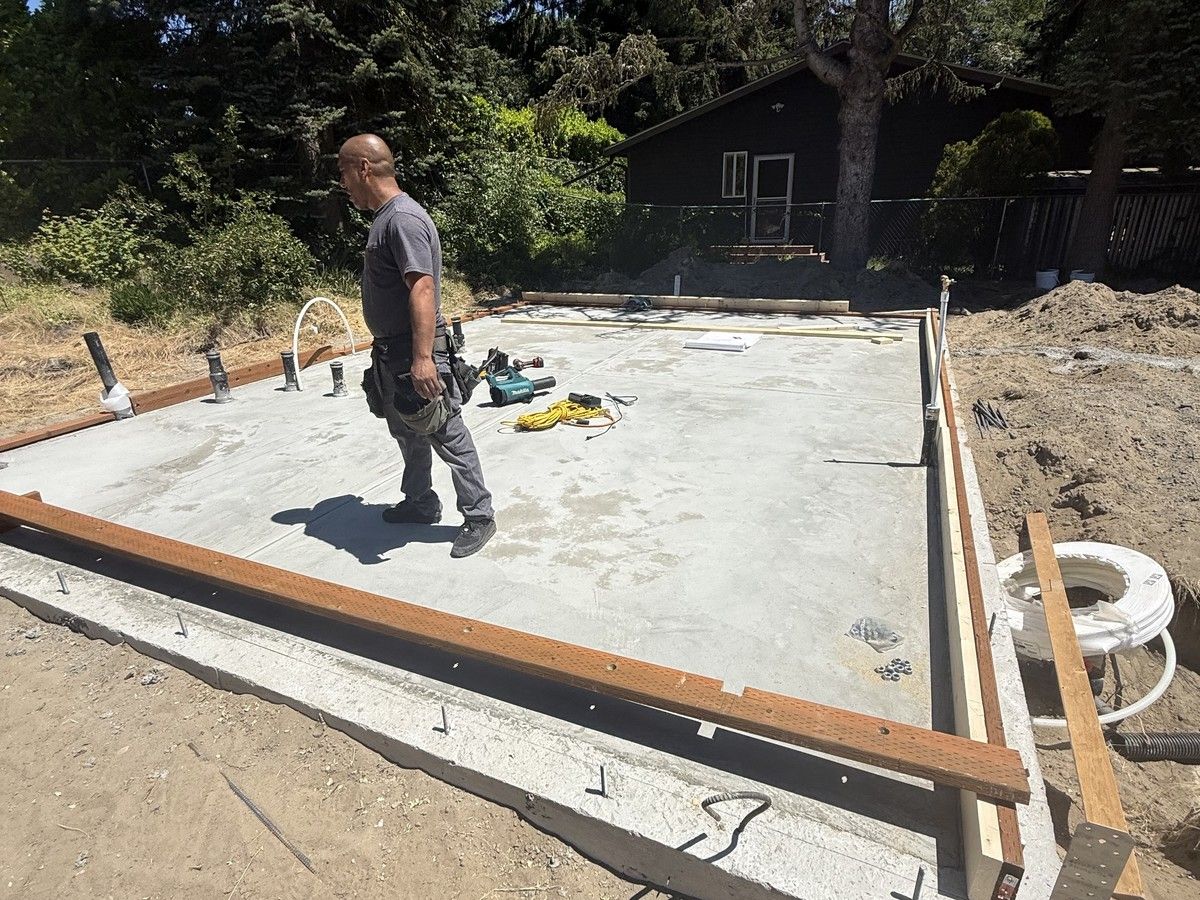 Crew laying out sill plates on the cured slab as framing begins